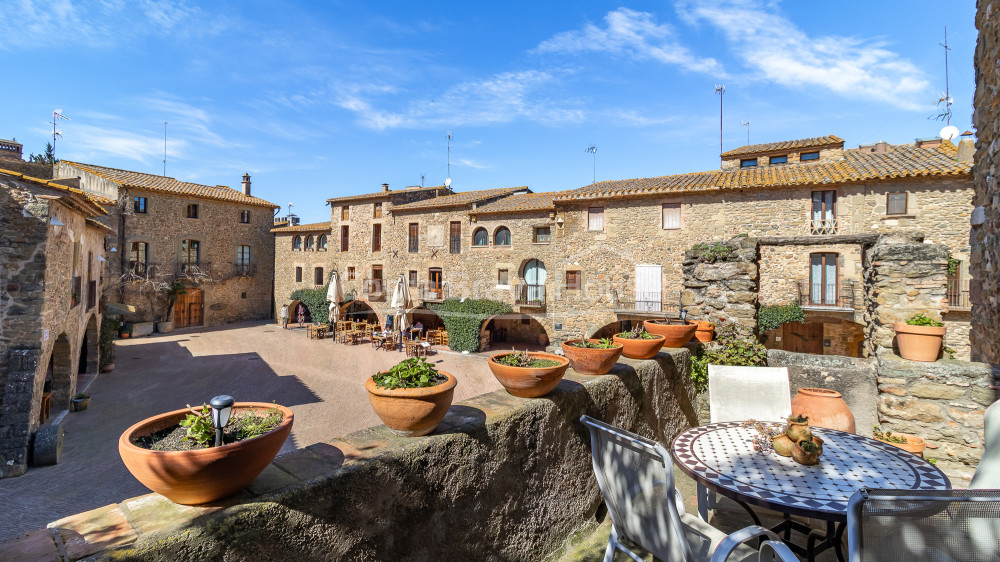 Casa de pedra a Monells amb pati interior, terrassa i vistes a la plaça medieval